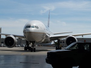 A Boeing 777-200 taxis toward the hangar